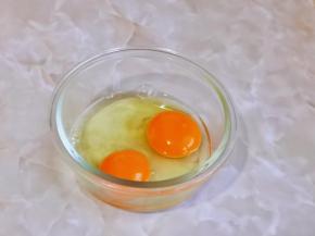 鸡蛋磕入碗中。
