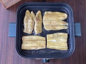 把茄子放入煎盘，两面煎至金黄。