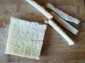 吐司切除四边，用擀面杖压一下。吐司切四边。中间不切段。