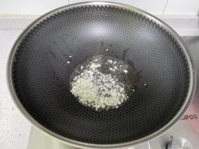 锅里下植物油，下入蒜末爆香。