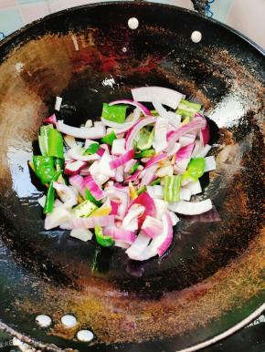 放入洋葱和青椒翻炒片刻！