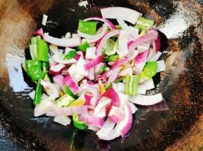 放入洋葱和青椒翻炒片刻！