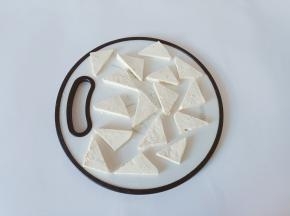 豆腐对半切开，再切成三角形。