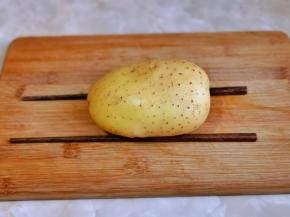 洗净的土豆下面垫一双筷子，如图所示。