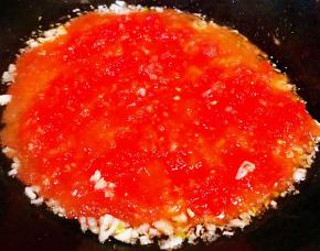 另起锅倒入底油放入蒜粒爆香再放入番茄泥炒匀