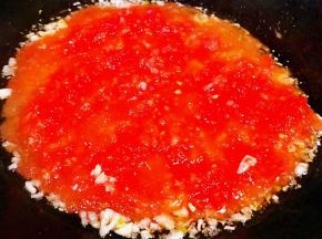 另起锅倒入底油放入蒜粒爆香再放入番茄泥炒匀