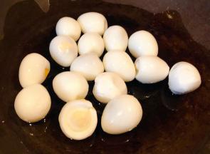 鹌鹑蛋煮熟去皮洗净沥干水份锅中倒入底油加热放入鹌鹑蛋中火煎起来