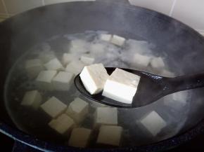 水开焯水一分钟，把豆腐捞出来自然晾凉，并且沥干水分。