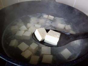 水开焯水一分钟，把豆腐捞出来自然晾凉，并且沥干水分。