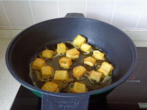 等豆腐定型再翻另外一面煎，煎至两面金黄盛盘。