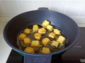 等豆腐定型再翻另外一面煎，煎至两面金黄盛盘。