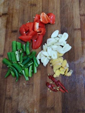 蒜瓣切成片，生姜切成片，干辣椒切成段。青椒和红辣椒切成块备用！