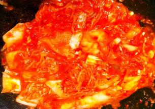 锅中倒入底油加热放入蒜粒爆香再放入辣白菜炒出香味