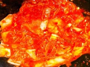 锅中倒入底油加热放入蒜粒爆香再放入辣白菜炒出香味