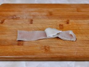 用刀把肉皮上的油脂刮干净，一定要彻底刮干净。