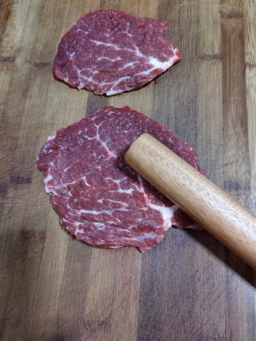 用锤子或者擀面杖把牛排敲打三分钟左右，把肉筋敲散，这样腌制出来的牛排才够鲜嫩，吃起来不会柴口！