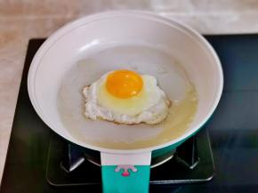 利用这时间煎蛋，锅中刷油，磕入鸡蛋，煎至蛋白凝固即可。