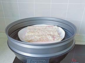 豆腐皮包上一层肉卷起来，锅里放适量的清水，把盘子放在蒸锅上面。