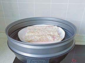 豆腐皮包上一层肉卷起来，锅里放适量的清水，把盘子放在蒸锅上面。
