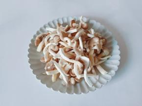 清洗好的秀珍菇挤干水分对半撕开。