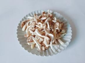 清洗好的秀珍菇挤干水分对半撕开。