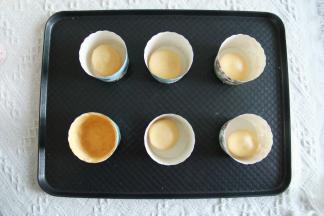 9、纸杯排入烤盘，此时预热烤箱上下185度。面团分成45克一个，搓圆放入纸杯。如果用小号纸杯，35-40克即可。