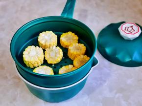 切好的玉米放入蒸格中。