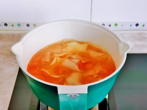 取下蒸好的玉米，番茄倒入奶锅中烧开下面片。