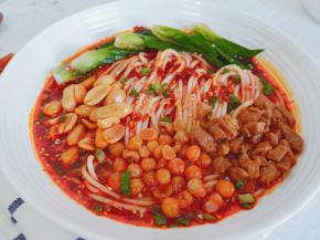 煮好的面条放入料汁里，放炒好肉沫，花生米，酥豌豆，撒点葱花与白芝麻即可食用。
