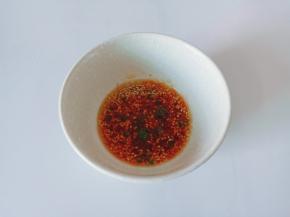 碗里放上辣椒酱，两勺生抽，米醋一勺，葱花芝麻少许。