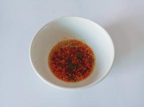 碗里放上辣椒酱，两勺生抽，米醋一勺，葱花芝麻少许。