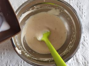 打好的蛋糊，用刮刀承接牛奶倒入，切拌翻拌均匀。