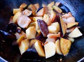 放入茄子和土豆大火炒至断生