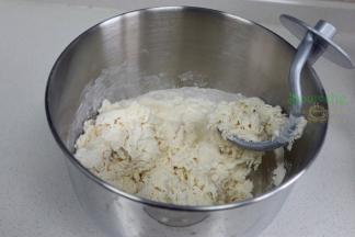 取500克中筋面粉，加入260克温水，倒入厨师机，搅拌揉搓光滑面团，盖上一块湿布，静放10分钟。