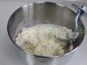 取500克中筋面粉，加入260克温水，倒入厨师机，搅拌揉搓光滑面团，盖上一块湿布，静放10分钟。