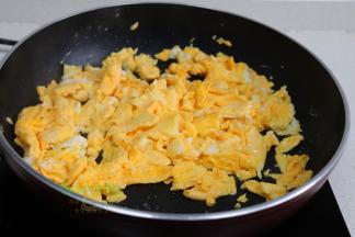 鸡蛋去壳，倒入一个玻璃碗里，打蛋器快速搅拌均匀。锅烧热之后，适量花生油，倒入鸡蛋液。中小火炒至鸡蛋是凝固状态，放盐炒均匀。