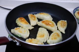 用筷子翻转韭菜盒子，另外一面也继续煎至焦黄，外皮酥脆，里面香软，热乎乎，很好吃。