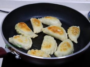 用筷子翻转韭菜盒子，另外一面也继续煎至焦黄，外皮酥脆，里面香软，热乎乎，很好吃。