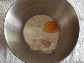 除了黄油和豆沙，其他材料倒入打面桶。盐、糖分开放在两个角落，不要和酵母接触。