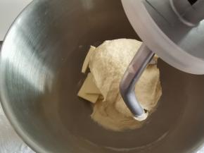 厨师机开1档混合成团，转3档揉面。将面团揉到光滑，扯开厚膜的状态，加入软化好的黄油，转低速让黄油和面团打到混合，再转高速揉面。