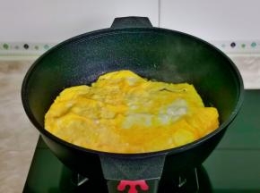 起油锅倒入打散的蛋液，煎蛋饼在铲碎盛出备用。