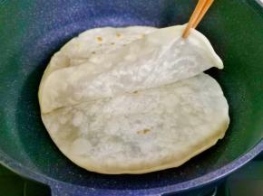 烙至底部变色，膨胀鼓起时翻面，趁热撕开，依次做完。