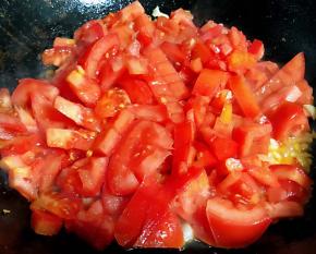 锅中倒入底油加热放入蒜粒爆香再放入西红柿大火快速翻炒