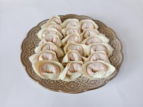 取一张馄饨皮放上肉馅包起来。