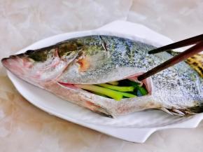 小葱去皮后塞进鱼肚子里。