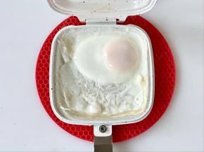 把三明治烤盘推入早餐机中，设置大火，时间5分钟，把鸡蛋煎好，因为给孩子吃，所以我煎的比较熟，如果喜欢溏心的可以缩短烤制的时间。