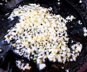 另起锅倒入底油加热放入蒜粒爆香