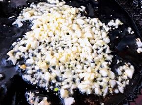 另起锅倒入底油加热放入蒜粒爆香