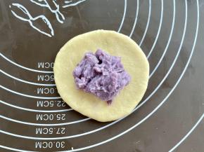 取一个面团擀圆，中间放上芋泥馅，约30克。
