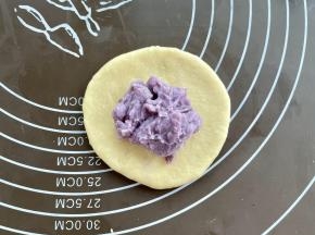 取一个面团擀圆，中间放上芋泥馅，约30克。